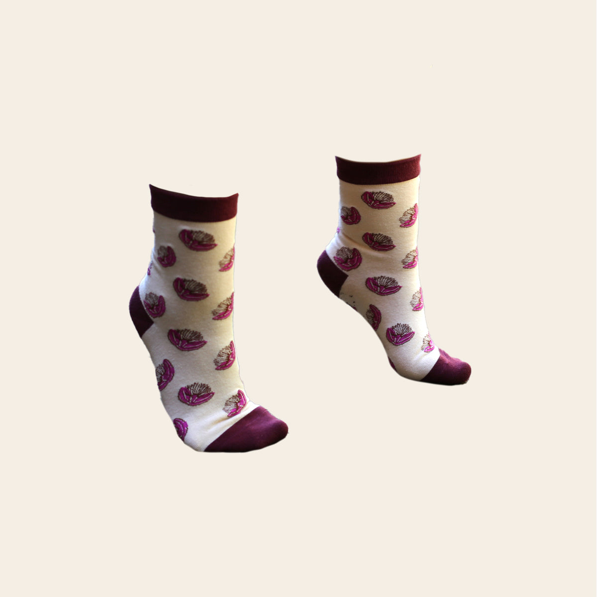 Pair of pink and magenta coloured socks shown on feet.