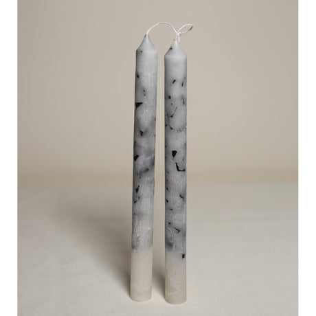 A pair of white marble effect table candles displayed upright on a light background.