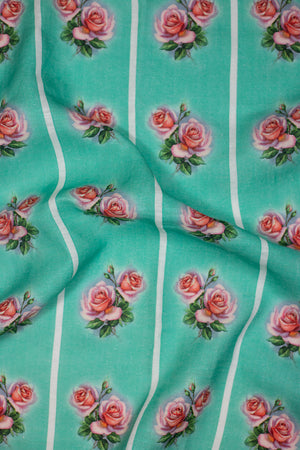 A vintage style green linen tea towel with a pink and green rose motif repeated vertically in four stripes down the tea towel.
