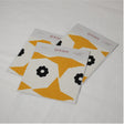 Three swatches of fabric with a yellow and black star pattern on a white background, laid out on a pale surface.