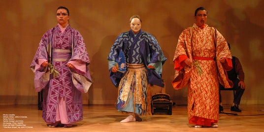 Three actors standing side by side dressed in brightly coloured printed kimono.