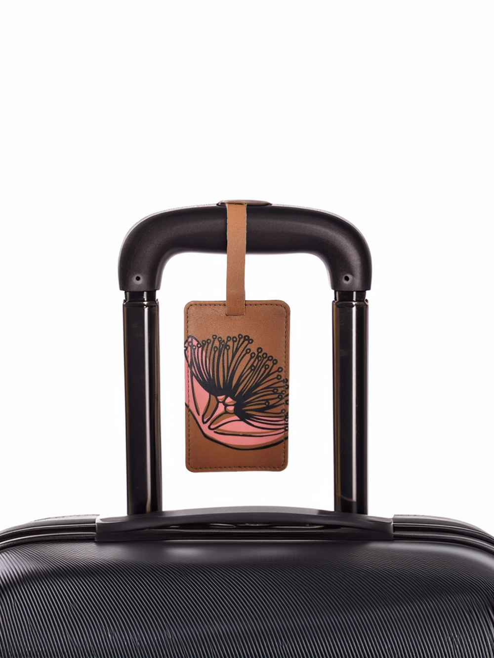 Mustard coloured tag on a black suitcase with dark green pohutukawa print on it.