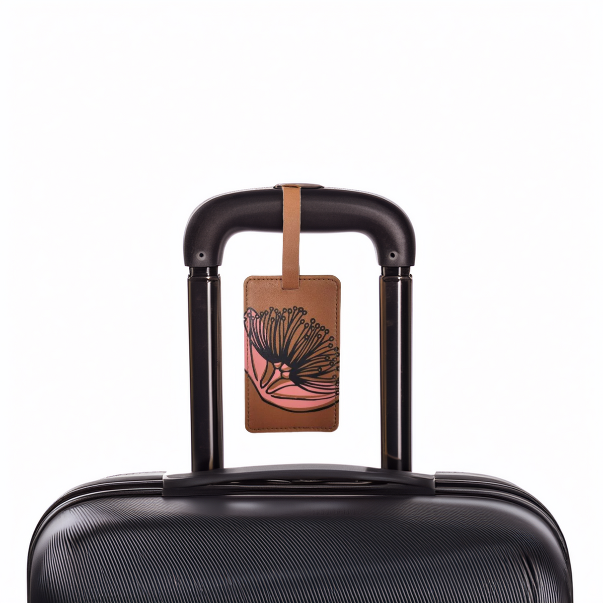 Mustard coloured tag on a black suitcase with dark green pohutukawa print on it.