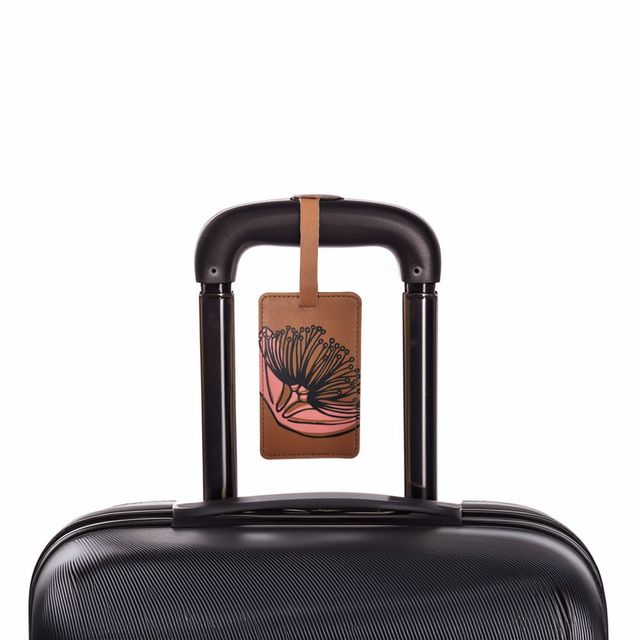 Mustard coloured tag on a black suitcase with dark green pohutukawa print on it.